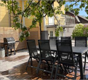 einen schwarzen Tisch und Stühle auf einer Terrasse mit Grill in der Unterkunft Villa Lotta in Hanko