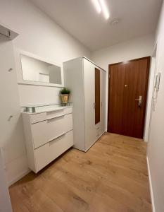 eine Küche mit weißen Schränken und Holzböden in der Unterkunft Renoviertes Apartment inkl TG Stellplatz in Düsseldorf in Düsseldorf