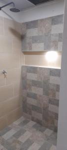 a bathroom with a shower with a stone wall at apartamento tranquilo rodeado de zonas verdes in Acacías