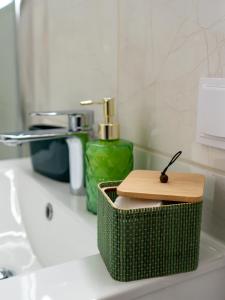 a bathroom with a green basket on a sink at Apartament Classic Comfort Aleja NMP 8 - Free parking in Częstochowa