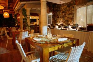 a dining room with a wooden table and white chairs at Villa Kapresse du 978 - Guest house in Marigot