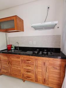 a kitchen with a sink and a stove at Flat em Taipu de Fora - Cond Vila Taipu in Barra Grande