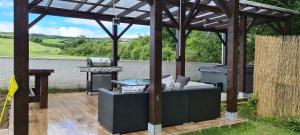 a wooden pergola with a grill and a barbecue at Annie's House with Thermal Health Spa in Moville