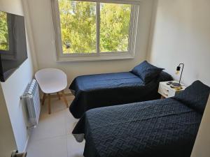 a small room with two beds and a window at Punta Tejada in Monte Hermoso +11 photos