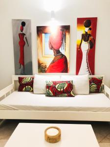 a white couch with pillows and paintings on the wall at Boavista Beach Apartment in Sal Rei