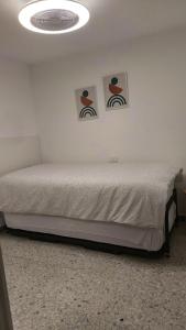 ein Schlafzimmer mit einem Bett mit zwei Bildern an der Wand in der Unterkunft 2 bedrooms appartement at Arrieta 300 m away from the beach with furnished terrace and wifi in Arrieta
