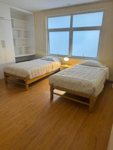 2 camas en una habitación con ventana grande en Apartamento Florentino 201, en Lima