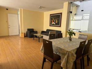 sala de estar con mesa, sillas y sofá en Apartamento Florentino 201, en Lima
