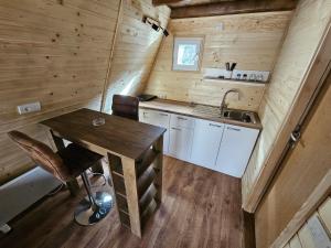 eine Küche mit einem Tisch und einem Waschbecken in einer Hütte in der Unterkunft Vikendica L&V home in Valjevo