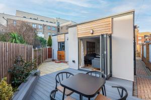 a small balcony with a table and chairs on a deck at Stylish 2 Bed Bungalow in East Ham, Close to Excel in London