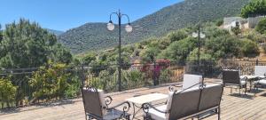 a deck with chairs and tables and a view of a mountain at Grand süit 402 in Kalkan