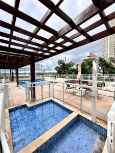 een groot zwembad met een patio met een dak bij 902. Flat Blend - Proibido fumar in Brasilia