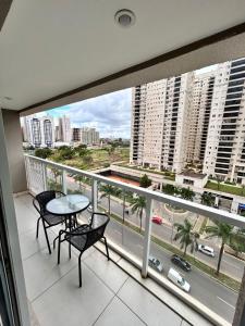 a balcony with a table and chairs and a view of a city at 902. Flat Blend - Proibido fumar in Brasilia