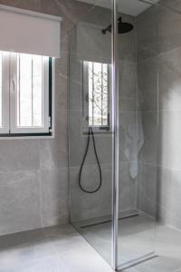 y baño con ducha y puerta de cristal. en Casa na Aldeia 1º Andar, en Arcos de Valdevez