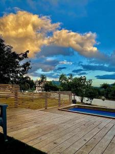 una terraza de madera con una valla y una piscina en PARAISOS DE GABRIELA en Villalba