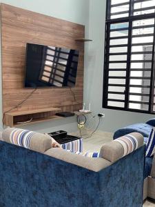 een woonkamer met een blauwe bank en een flatscreen-tv bij Hermosa casa en Salinas! in Salinas