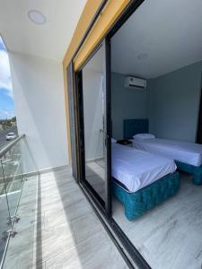 een slaapkamer met een bed en een glazen balkon bij Hermosa casa en Salinas! in Salinas
