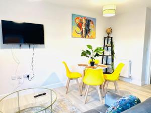 Cosy Dover suite w Free Parking في Kent: غرفة معيشة مع طاولة وكراسي صفراء