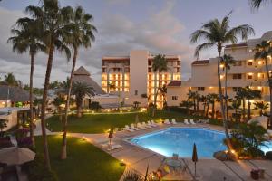 an aerial view of a hotel with a pool and palm trees at Beachfront condo in Los Cabos, Mexico in San José del Cabo