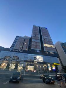 a tall building with cars parked in a parking lot at RentNow Large and Cozy Apartment in the Center, Parking in Chişinău