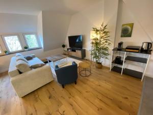 a living room with a couch and a tv at Stadtoase: Exklusive Apartments für Ruhe und Entspannung in Bremen