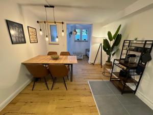 uma sala de jantar com uma mesa de madeira e cadeiras em Stadtoase: Exklusive Apartments für Ruhe und Entspannung em Bremen