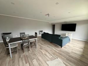 a living room with a couch and a table and a tv at Casa Náutico con estacionamiento privado in Río Gallegos