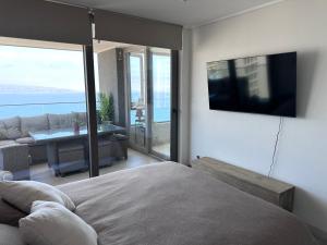 1 dormitorio con 1 cama y TV en la pared en Departamento con Vista al mar, en Viña del Mar