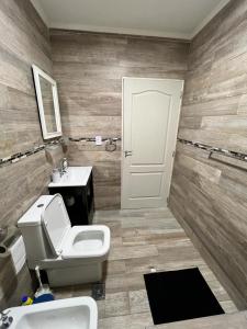 La salle de bains est pourvue de toilettes blanches et d'un lavabo. dans l'établissement Casa Náutico con estacionamiento privado, à Río Gallegos