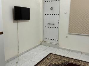 a room with a door with a television and a rug at Studio parfaitement confortable in Nouakchott