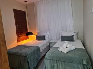 two beds sitting next to each other in a room at Brisas do Sul Condo Boutique in Pipa +34 photos