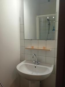 a white sink in a bathroom with a mirror at Appartement centre in Aire-sur-lʼAdour