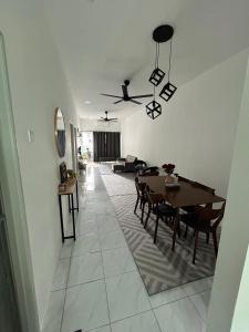 a dining room and living room with a table and chairs at Zh homestay teluk batik in Lumut