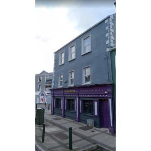 un edificio con adornos púrpura en una calle de la ciudad en The corner house Longford town, en Longford