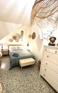 DOMMO ASULETTA في بوسا: غرفة نوم بسرير وخزانة بيضاء