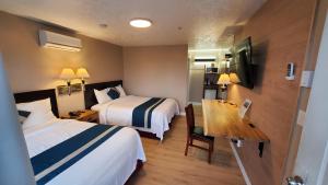 Un pat sau paturi într-o cameră la Harbour Light Motel