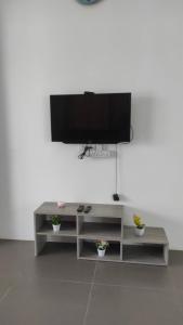 a entertainment center with a flat screen tv on a wall at Aaira Homestay d'Alor Setar in Alor Setar