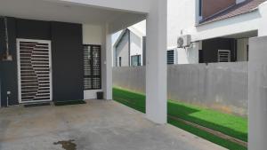 an external view of a house with green grass at Aaira Homestay d'Alor Setar in Alor Setar