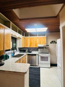 a kitchen with white appliances and wooden cabinets at 3 BHK House in Cultus Lake in Chilliwack