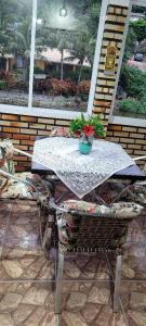 een tafel en stoelen op een patio met een raam bij Aconchego Lagoinha in Florianópolis