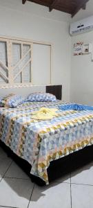 ein Schlafzimmer mit einem Bett mit einer Decke darauf in der Unterkunft Aconchego Lagoinha in Florianópolis