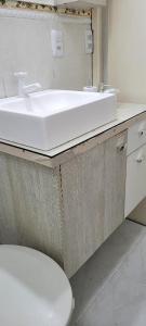 een badkamer met een witte wastafel en een toilet bij Aconchego Lagoinha in Florianópolis