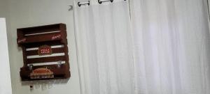 a window with a white curtain with a cake on it at Aconchego Lagoinha in Florianópolis