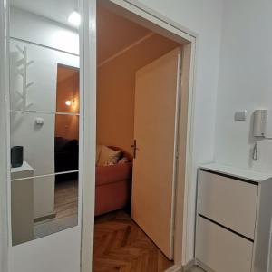 a door leading into a room with a couch at Red Square Apartment in Pirot