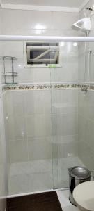 uma casa de banho com uma cabina de duche em vidro e um WC. em Aconchego Lagoinha em Florianópolis
