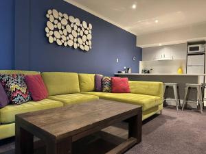 Una sala de estar con un sofá amarillo y una mesa. en White Crystal 110, en Monte Hotham