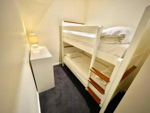 Habitación pequeña con 2 literas y lámpara. en White Crystal 110, en Monte Hotham