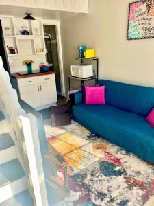 sala de estar con sofá azul y almohadas rosas en Pop-Of-Color - Loft - Downtown Raleigh - Near NCSU en Raleigh