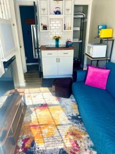 a living room with a blue couch and pink pillows at Pop-Of-Color - Loft - Downtown Raleigh - Near NCSU in Raleigh