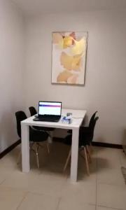 ordenador portátil en un escritorio blanco en una habitación en Eagle's Nest - 2BR Furnished with Fast Internet and Netflix, en Davao City